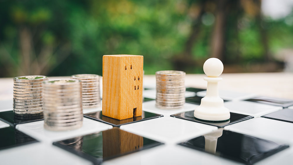 Wooden building chess piece with coin stacks